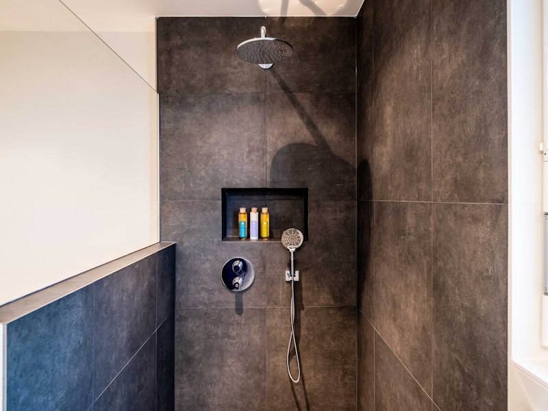 Premium dark-tile steam shower with rain head and niche